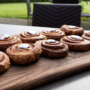 Friskbagte kanelsnegle på et træfad